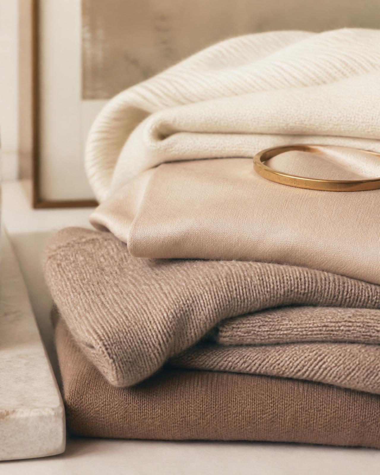 Tecidos dobrados em tons neutros — cashmere, seda e lã